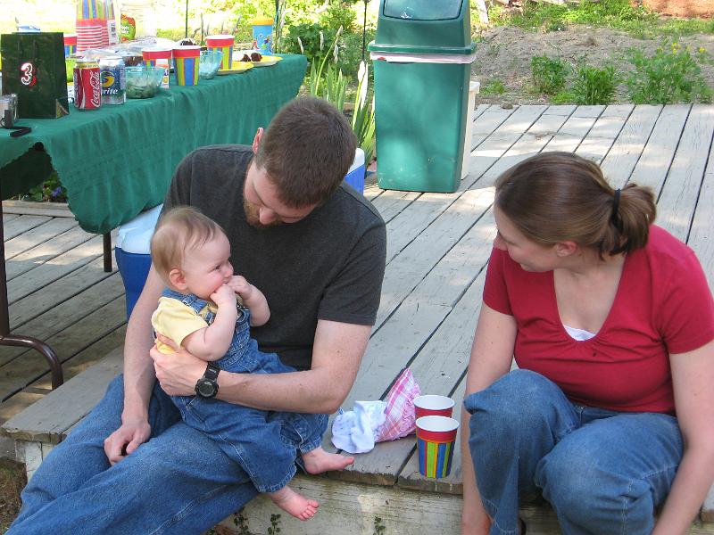 IMG_1978.JPG - Molly says, "if you won't feed me cake I'll just chew my fingers off instead!"  Mom and Dad seem amused by this.